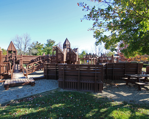 school playground made of wood sitting in gravel