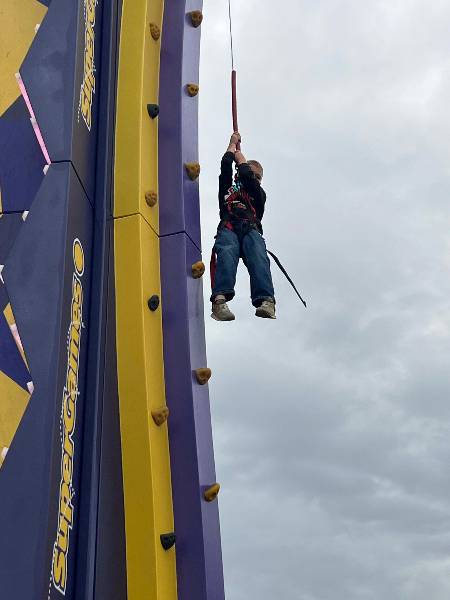 Boy hanging from the rope after his climb