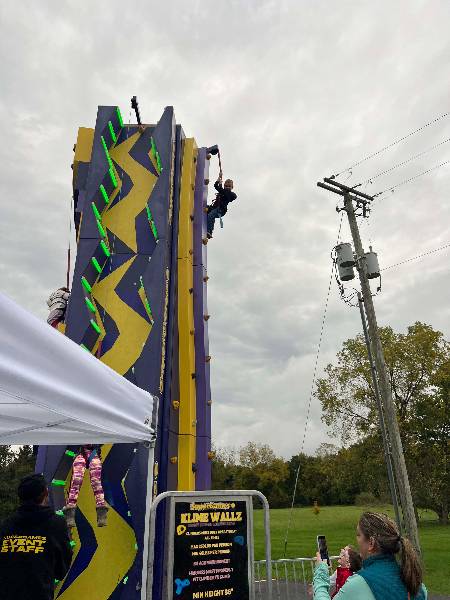 Boy reaching the top of the climbing wall