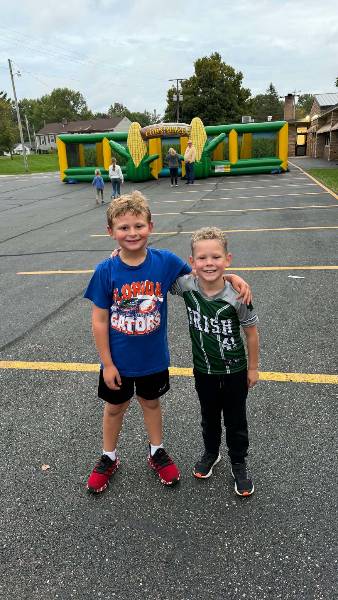 Two friends in front of the inflatable corn maze