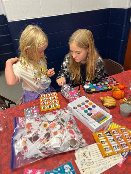 Volunteer helping a girl pick a design