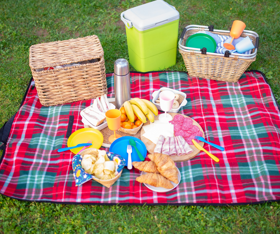 picnic basket on a banket with food layed out