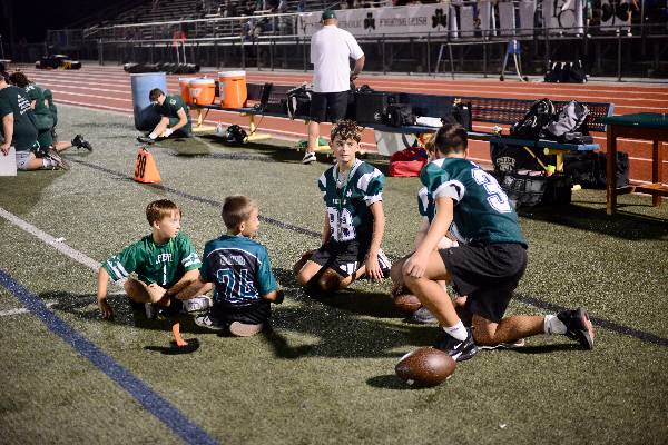Young players on the sideline at a night game