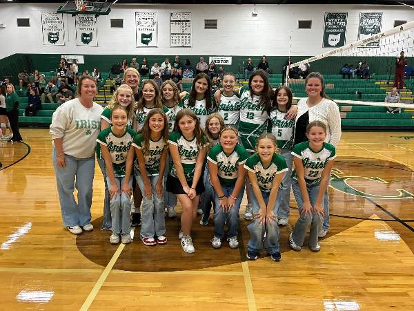 Youth volleyball team smiling with coaches